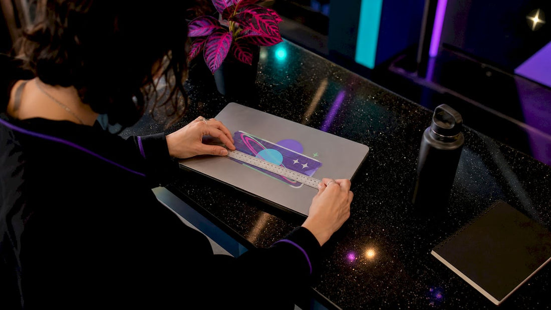 Person measuring laptop lid for sticker size